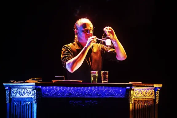 Bubble Cube Stephan Masur Seifenblasenshow Ein Mensch mixiert Cocktails hinter einer beleuchteten Bartheke.