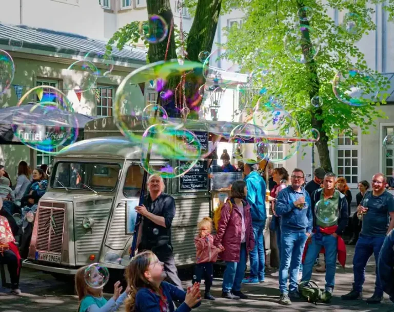 Seifenblasen Walk Act Stephan Masur Ein Künstler macht Riesenseifneblasen umringt von Publikum