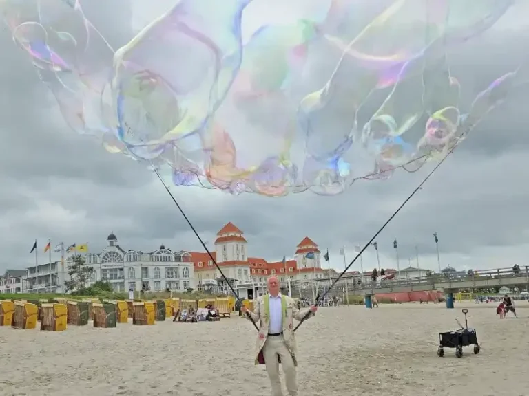 Stephan Masur Walk Act mit Riesenseifenblasen am Strand Ein Mann macht Riesenseifenblasen an einem Strand