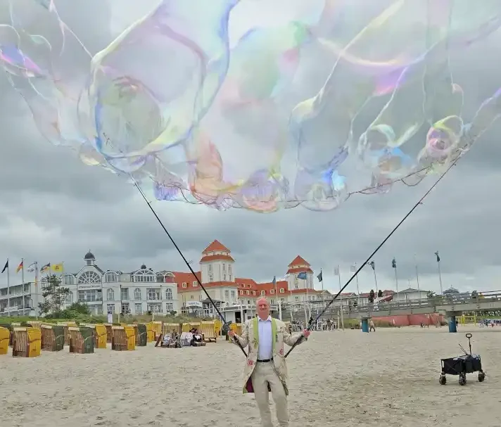 Seifenblasenwalkact mit Riesenseifenblasen Stephan Masur Ein Mann macht Riesenseifenblasen am Strand