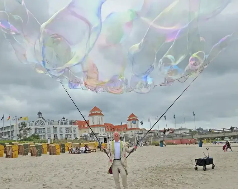 Seifenblasen Walk Act mit Riesenseifenblasen Ein Mann macht riesige Seifenblasen am Strand