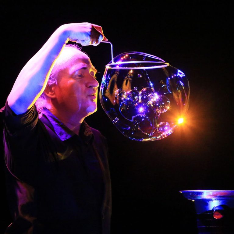 Seifenblasenshow Karlsruhe Seifenblasen Galaxyiesenseifenblasen Ein Zauberkünstler kreiert große Seifenblasen mit begeistertem Ausdruck.