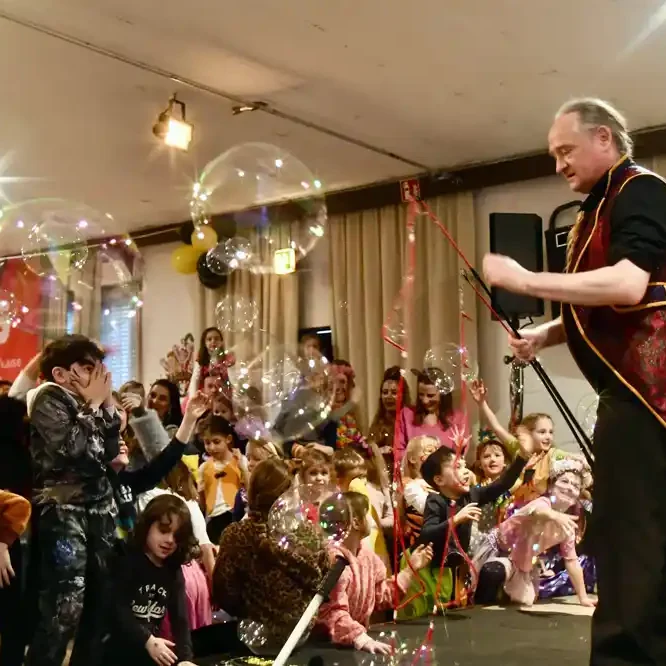 Karnevalsprogramm Kindersitzung: Seifenblasen-Act als Highlight für Bühne und Saal Ein Zauberer führt eine Show vor einem staunenden Publikum mit Seifenblasen.