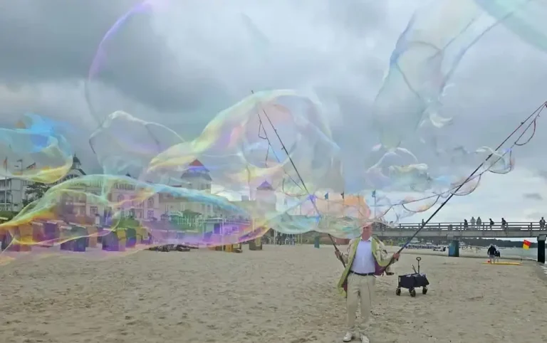 Seifenblasen Walk Act am Meer Ein Seifenblasenkünstler macht grosse Seifenblasen am Strand