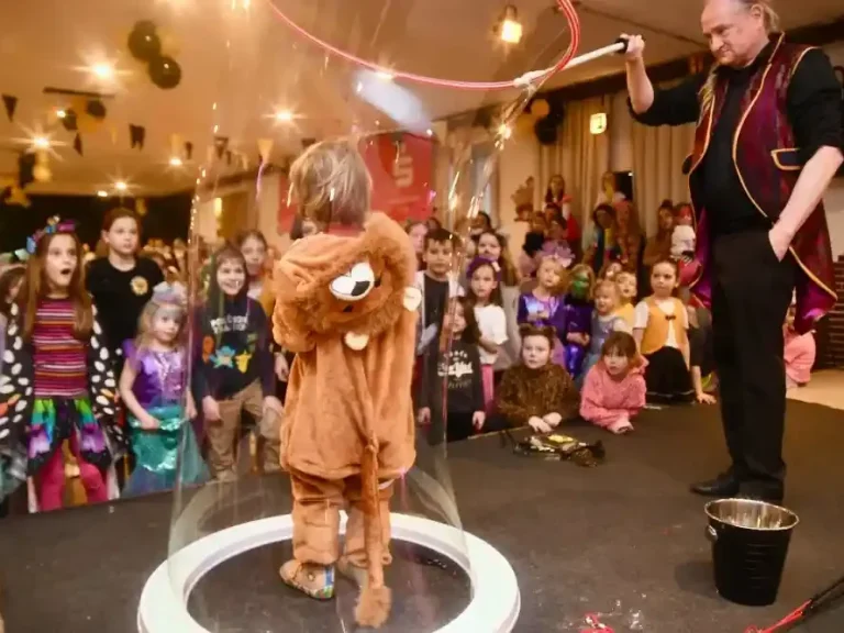 „Kindersitzung mit Seifenblasen: interaktive Bubble-Show sorgt für Lachen, Staunen und Applaus“ Kind in einem Löwenkostüm steht in einer Seifenblase, während Kinder zuschauen.